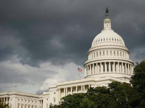 U.S. Capitol Building with dark stormy clouds above.