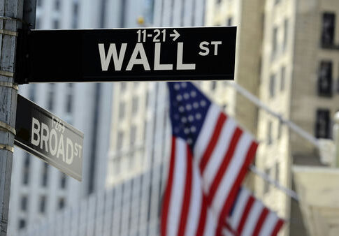Wall Street sign with American flag in background
