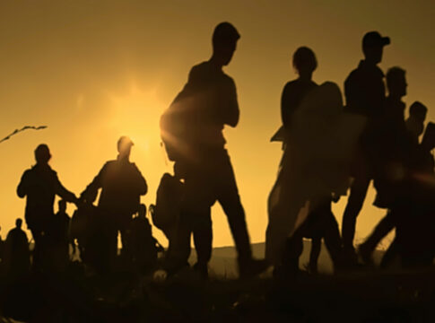 Silhouettes of people walking at sunset