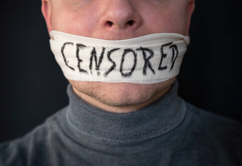 Person with a cloth labeled CENSORED covering their mouth