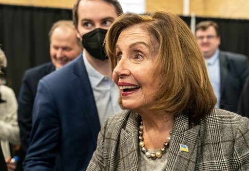A woman smiling and engaging with a group of people indoors