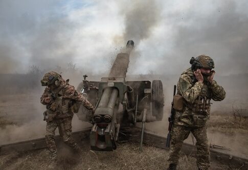 Soldiers operating a cannon in a smoky battlefield